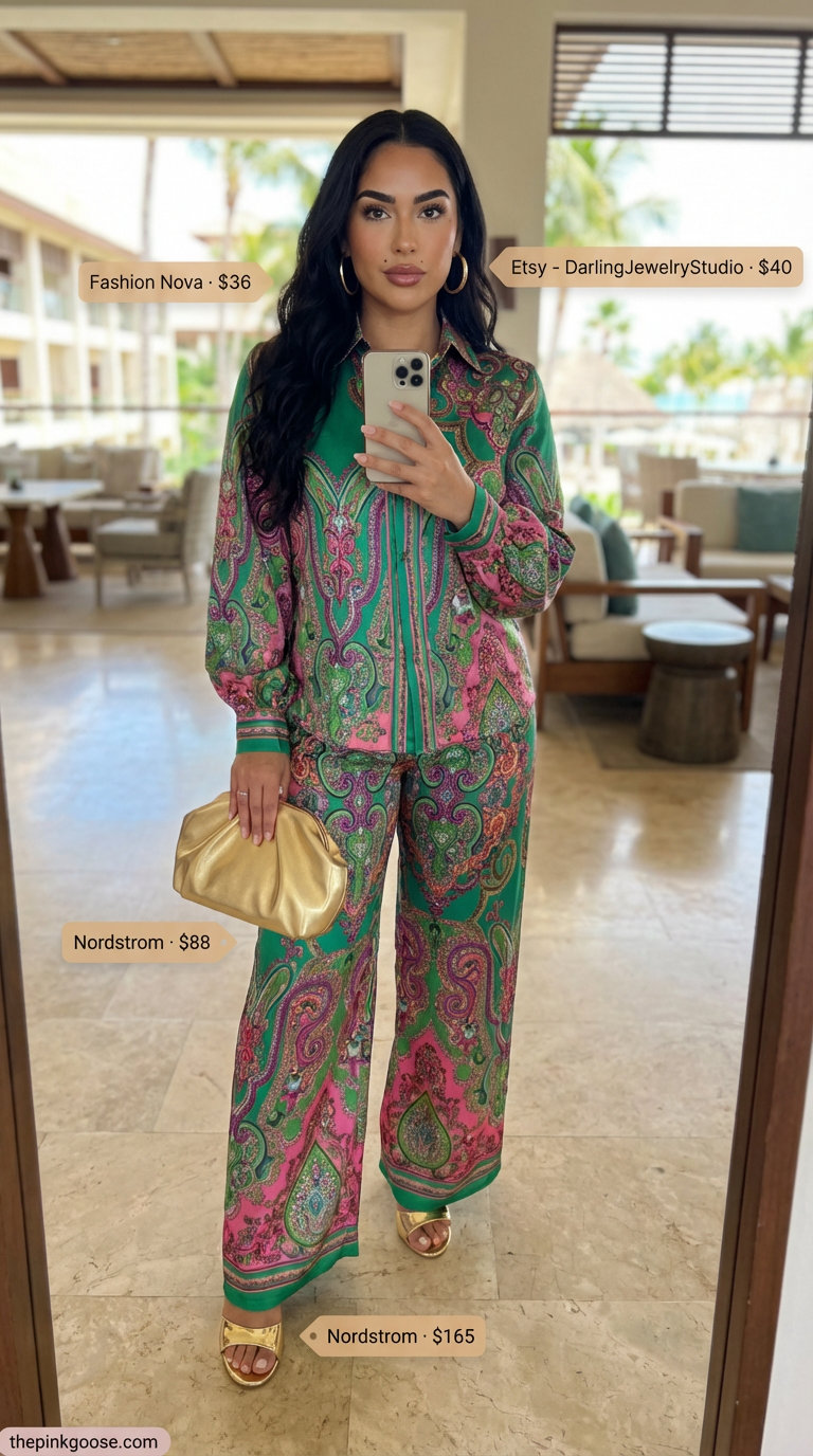 Glamorous summer beach outfit for women 2026: emerald green and fuchsia tropical print two-piece set (cropped shirt, wide-leg pants), gold heeled mules, large hoop earrings, and a metallic clutch for resort.