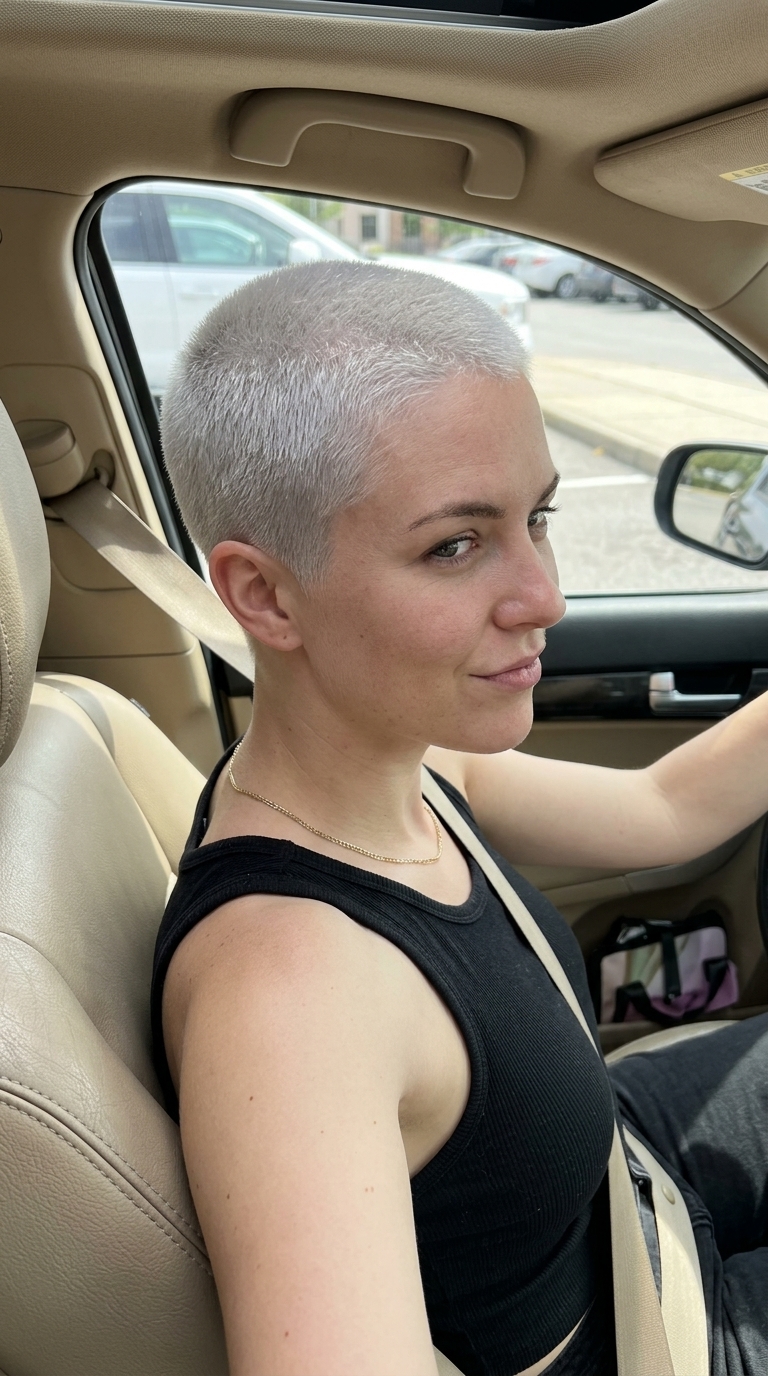 very short platinum blonde buzz cut with cool white, grey undertones, uniform clipper cut, bold rebellious style for fashion event