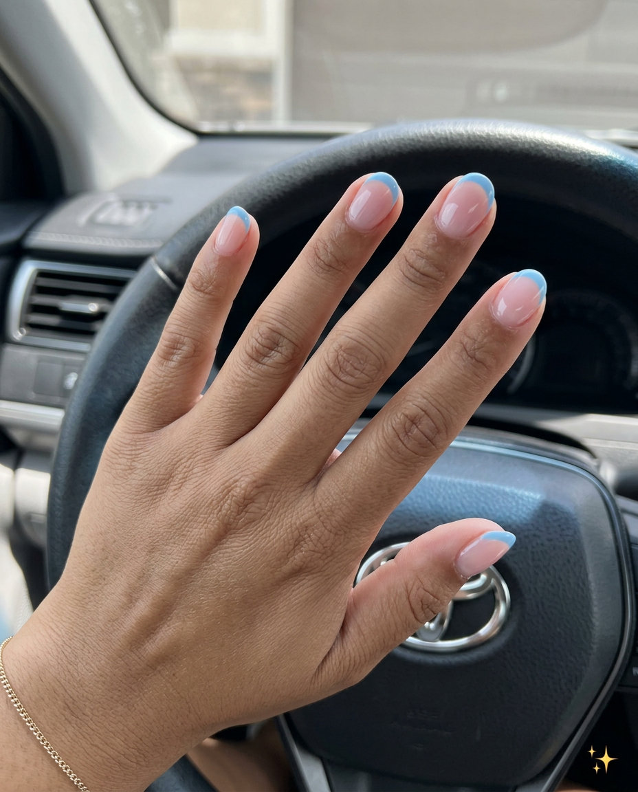 Short round summer nails 2026: Sky blue reverse French tips on sheer nude base for vacation.