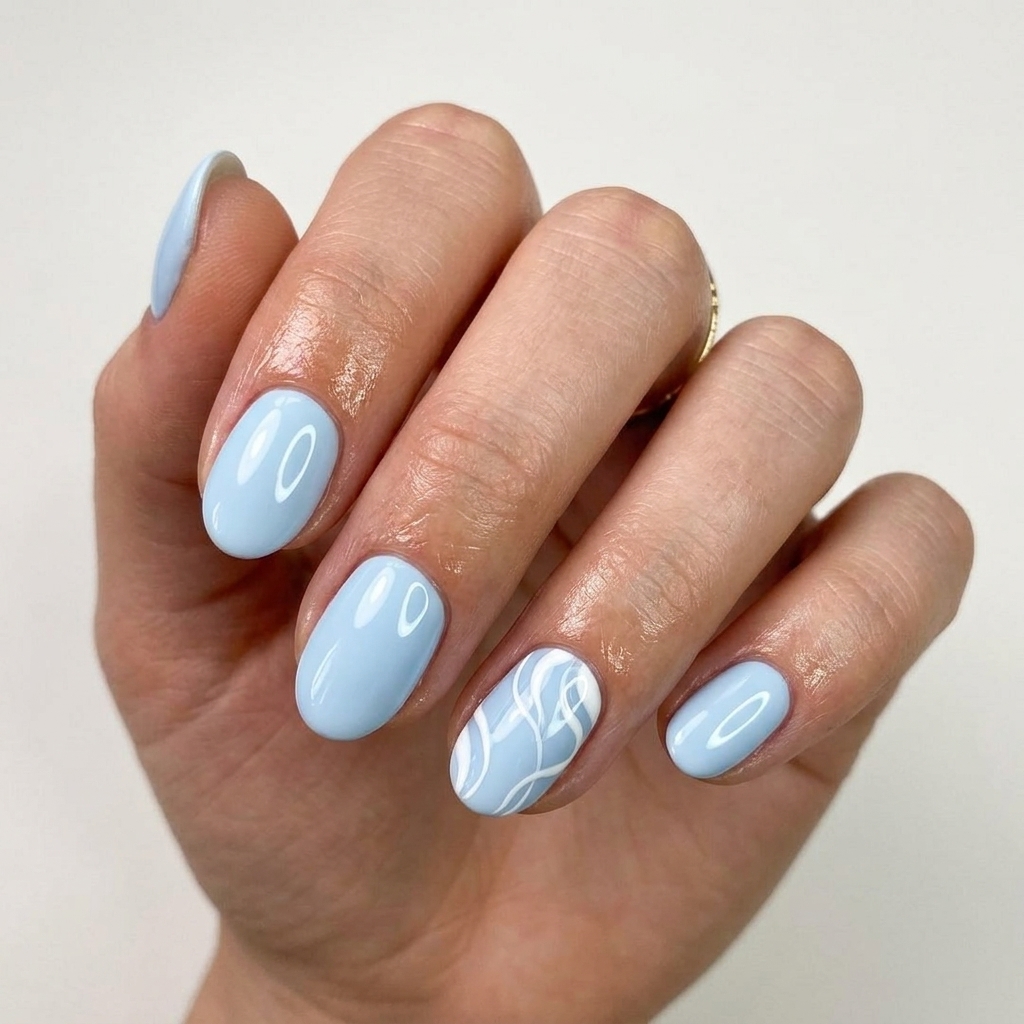 Pale sky blue swirl accent nails 2026: Short oval nails with white swirls for vacation and casual weekends.