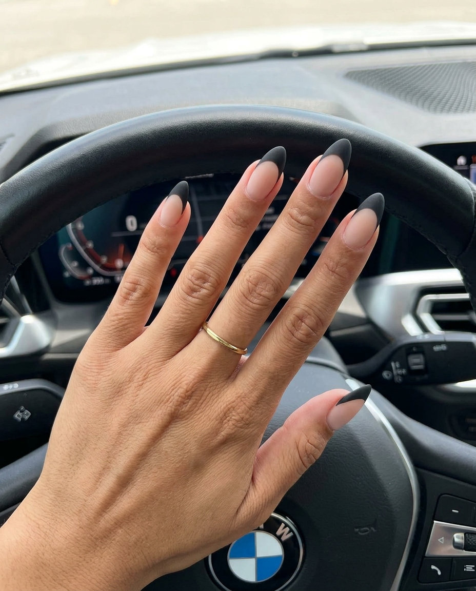 Simple Summer Acrylic Nail Designs 2026: Gothic Almond Medium almond sheer nude acrylic nails with a matte black reverse French tip for simple summer acrylic nail designs 2026.