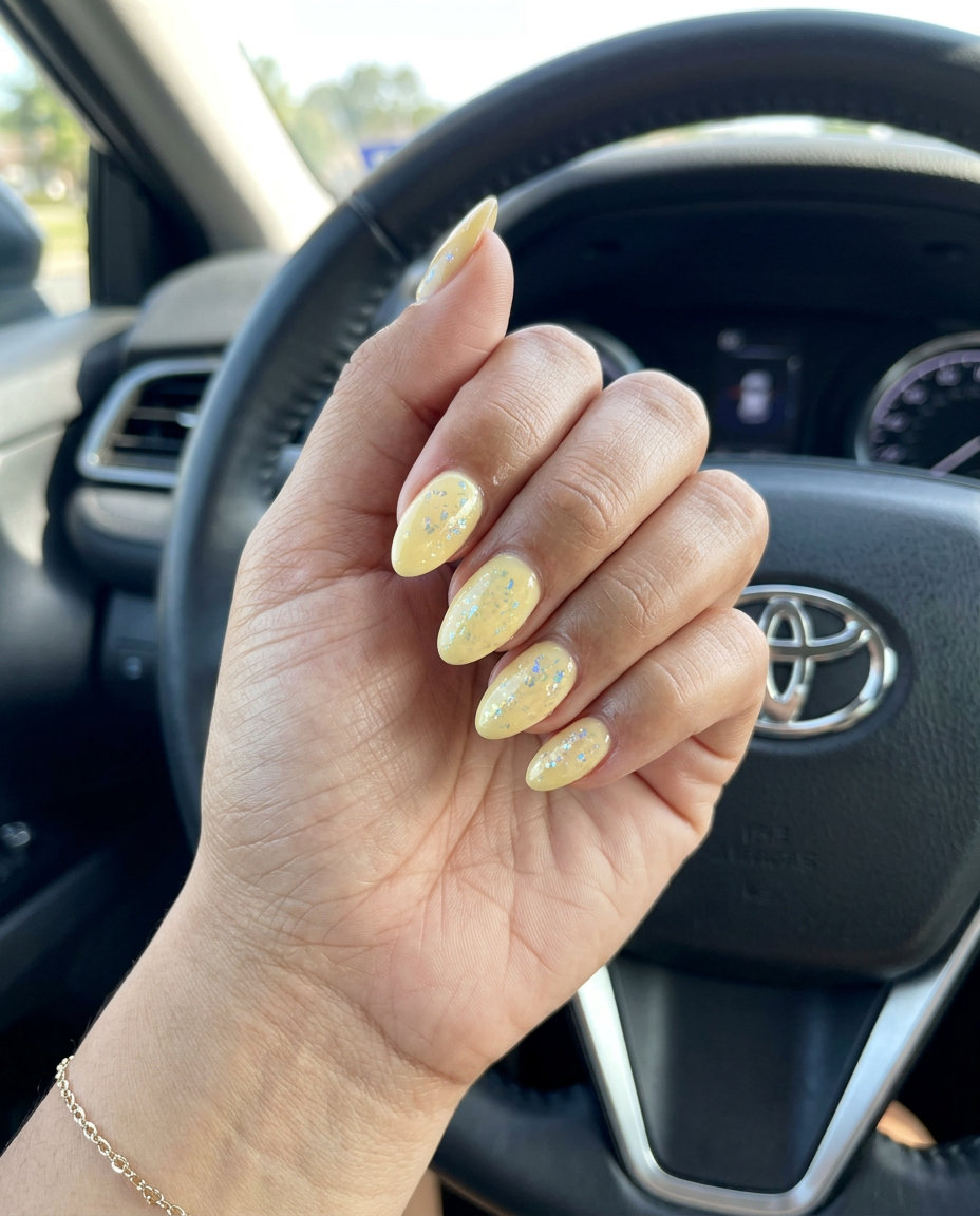 Golden hour foil butter yellow dip nails 2026 for festival or summer evening. Iridescent flakes.