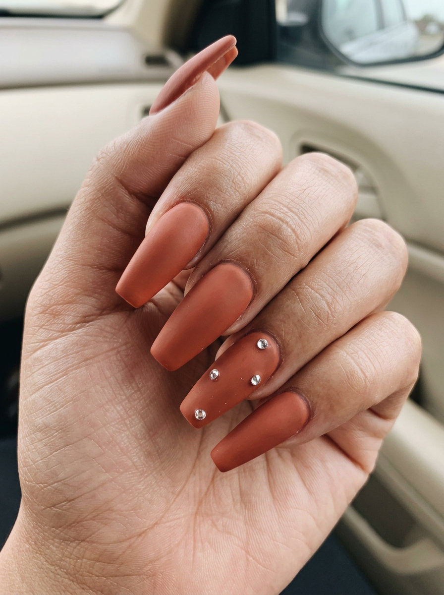 Summer matte nails 2026: Glamorous terracotta sunstone sparkle with crystal accents for summer travel.