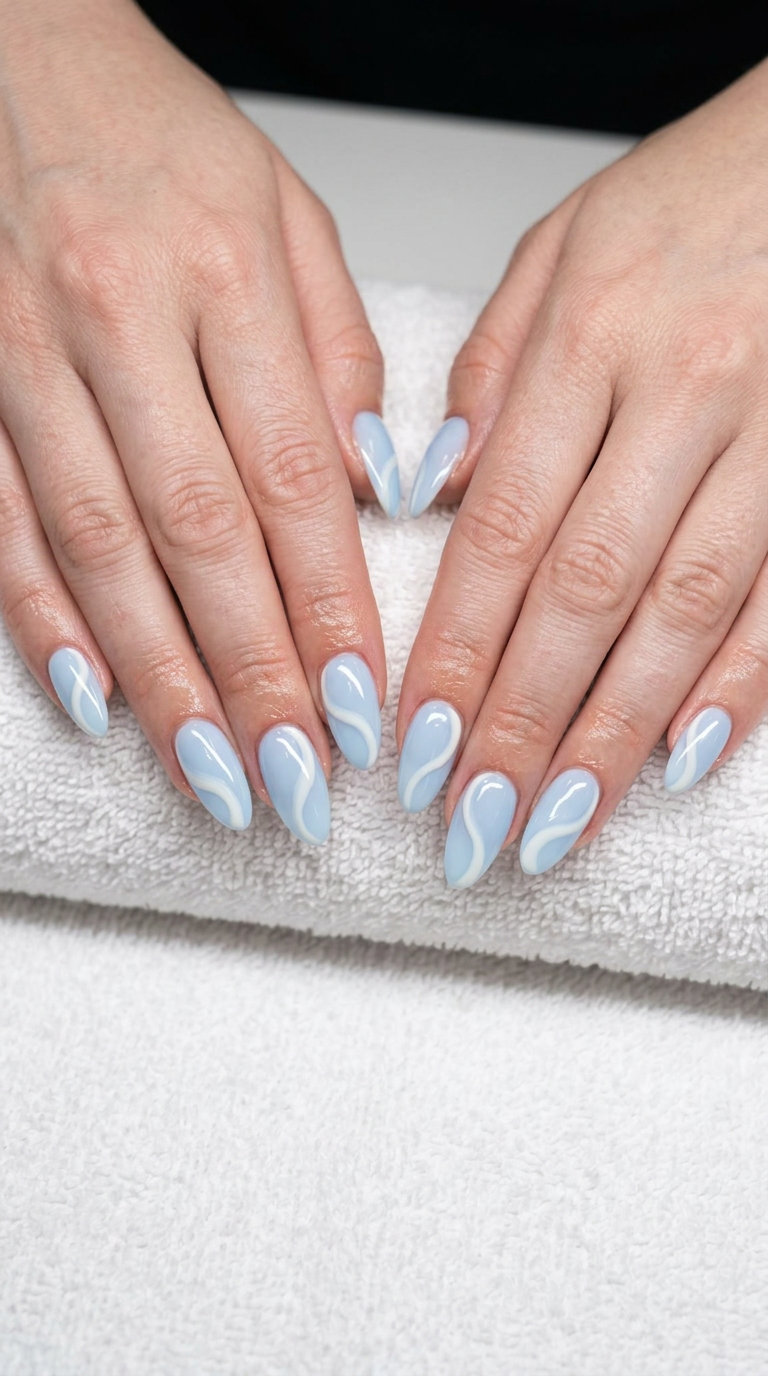 Baby Blue Swirls Almond Nails 2026 Baby Blue Swirls Almond nails for summer 2026: Romantic dreamy abstract art on elegant almond shape.