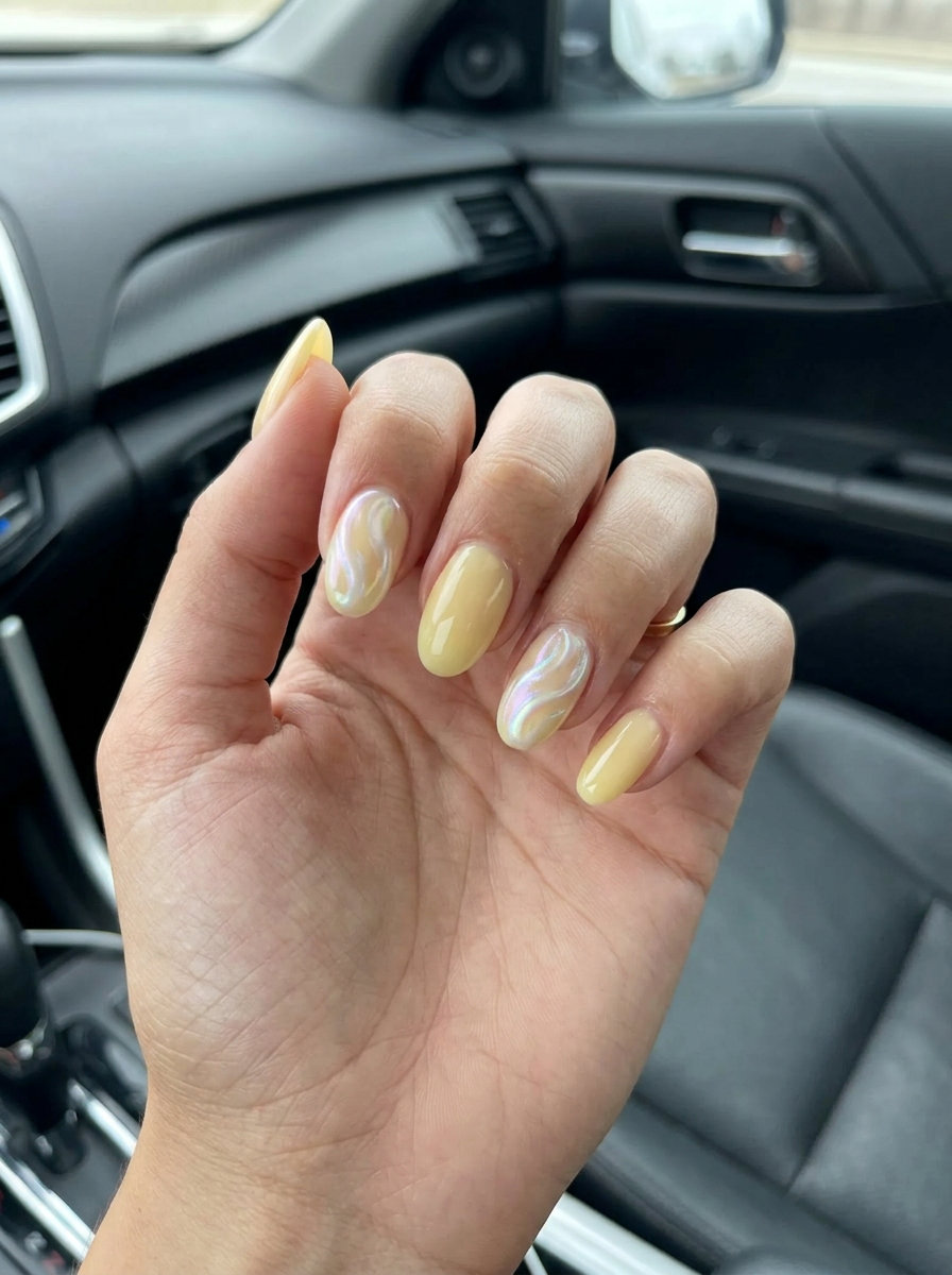 Yellow Summer Nails 2026: Pearlescent Swirls Soft butter yellow nails with pearlescent white swirls for weddings and date nights in summer 2026.