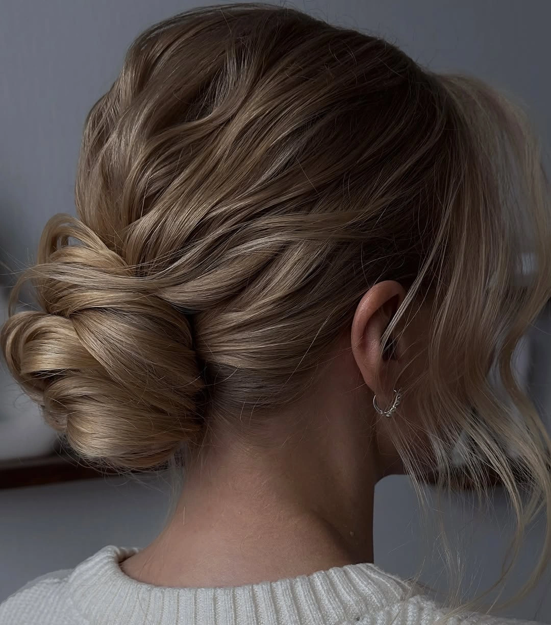 modern fall hairstyles for wedding guests 2026 Soft Twisted Low Bun With Face-Framing Pieces