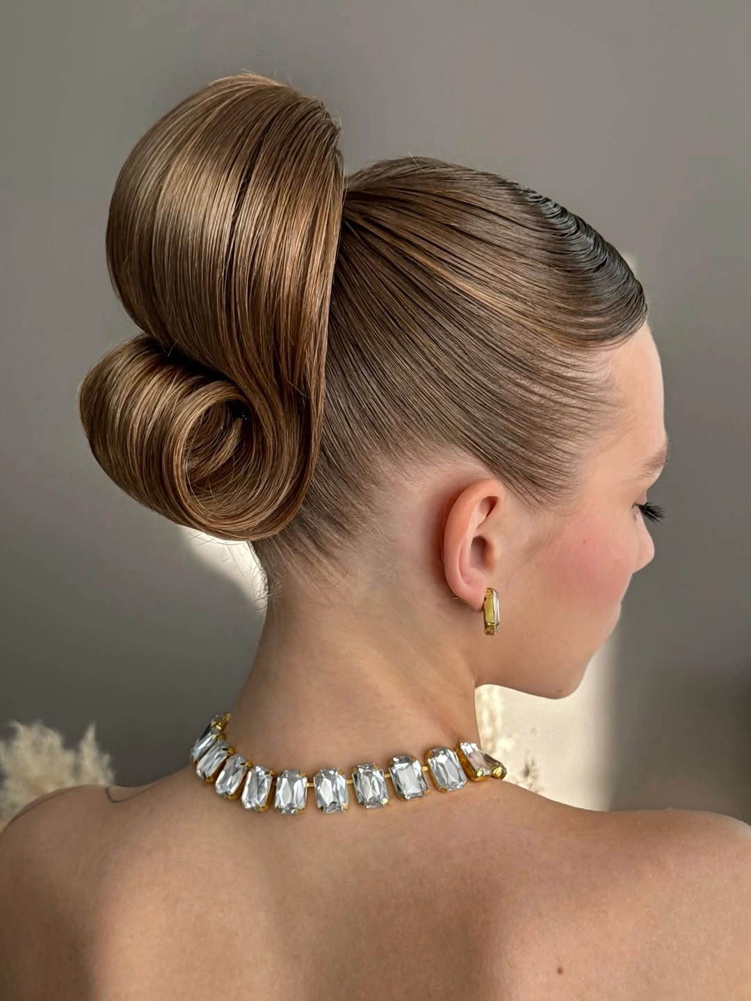 romantic bridesmaid hairstyling Elegant Sculptural Bun with Sleek Finish
