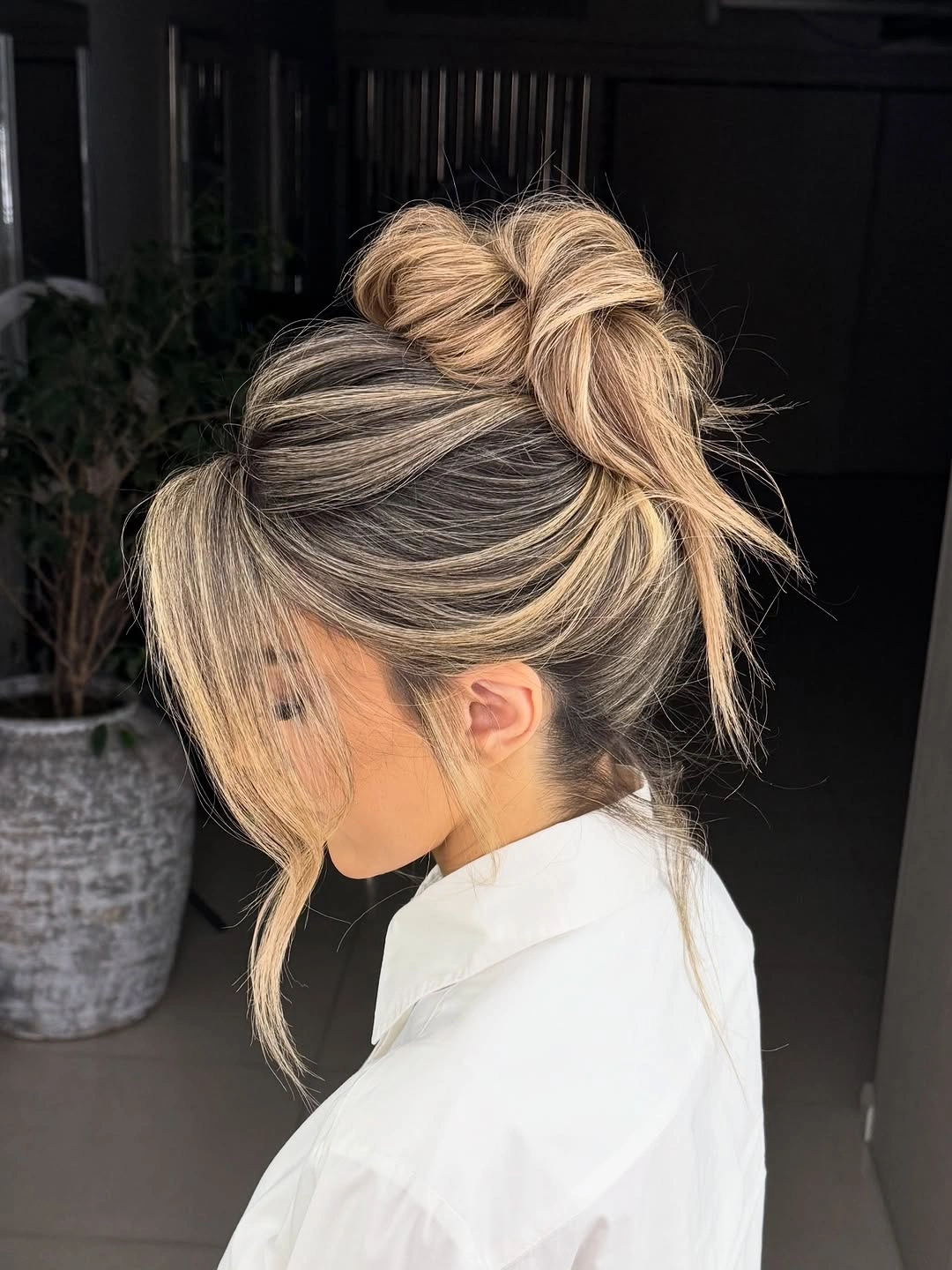 romantic bridesmaid hairstyling A Relaxed Textured Bun With Soft Face-Framing Pieces