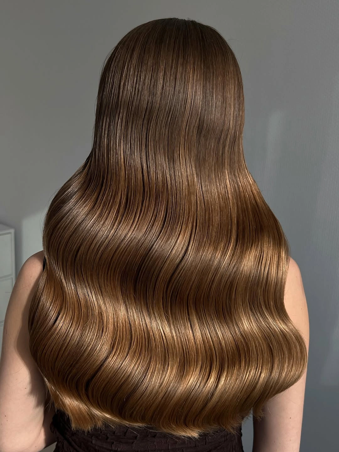 stylish body waves hairstyle Glossy Chestnut Waves With a Glass Hair Finish