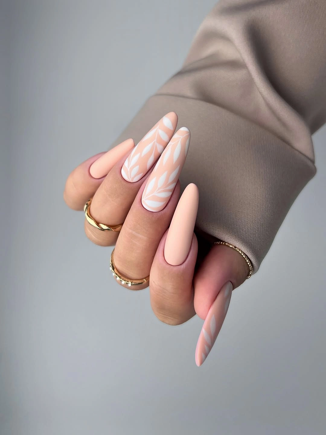beautiful matte fall nails design 2026 Soft Peach Almond Nails With White Leaves