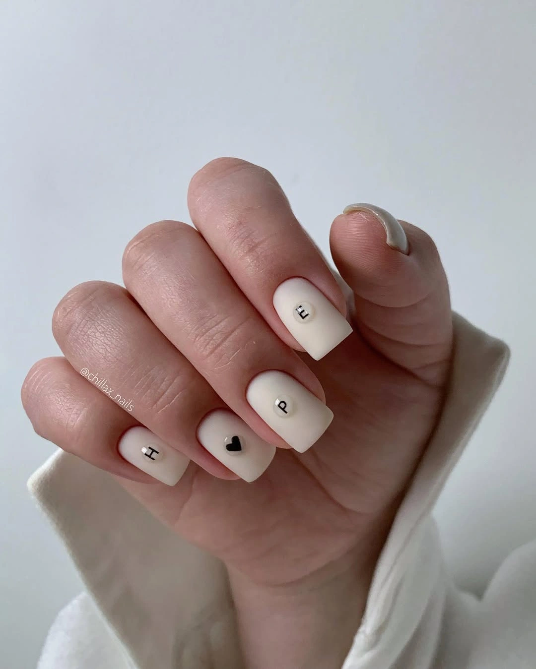 chic nude fall nails 2026 Ivory Nude With Tiny Black Initials