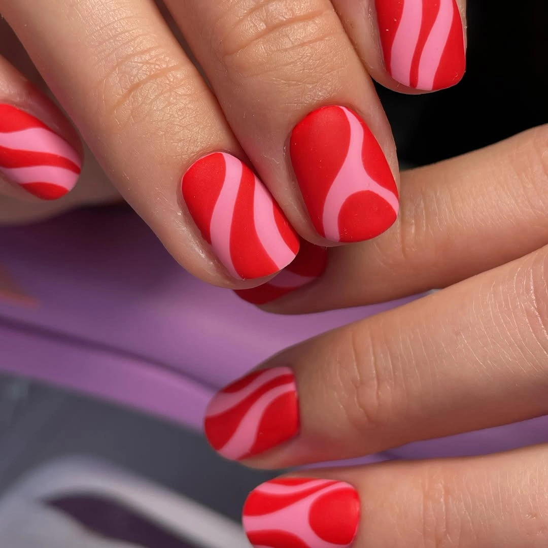 elegant fall matte nails 2026 Red and Pink Matte Swirl Nails