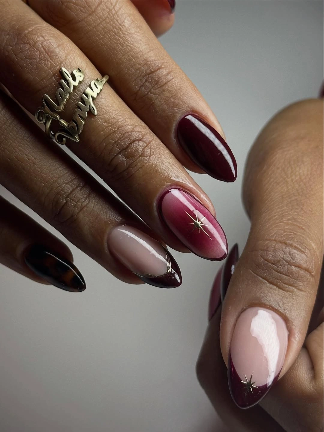 Luxurious maroon fall nails 2026 glossy burgundy with star details