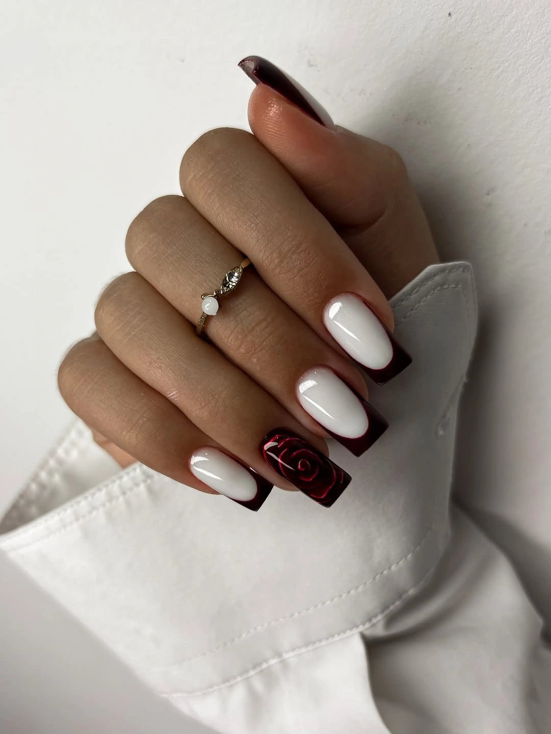 stylish fall french nails 2026 Burgundy French Tips With A Statement Rose Accent