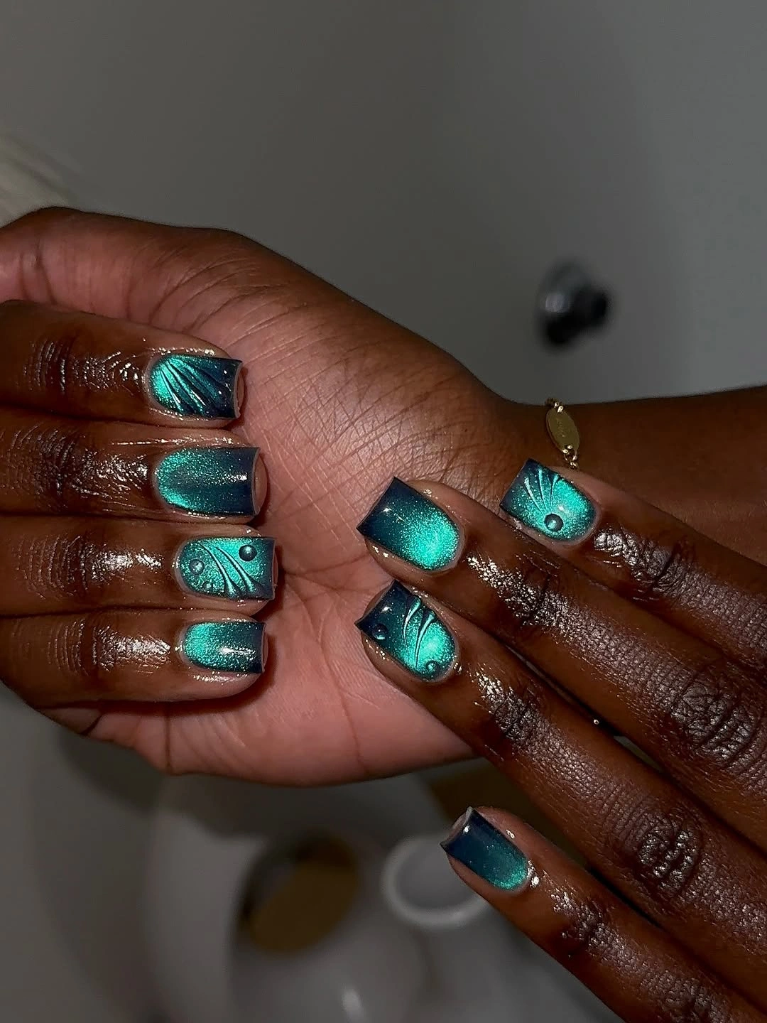 stylish fall nails for dark skin 2026 Magnetic Teal Cat-Eye Nails With Botanical Details