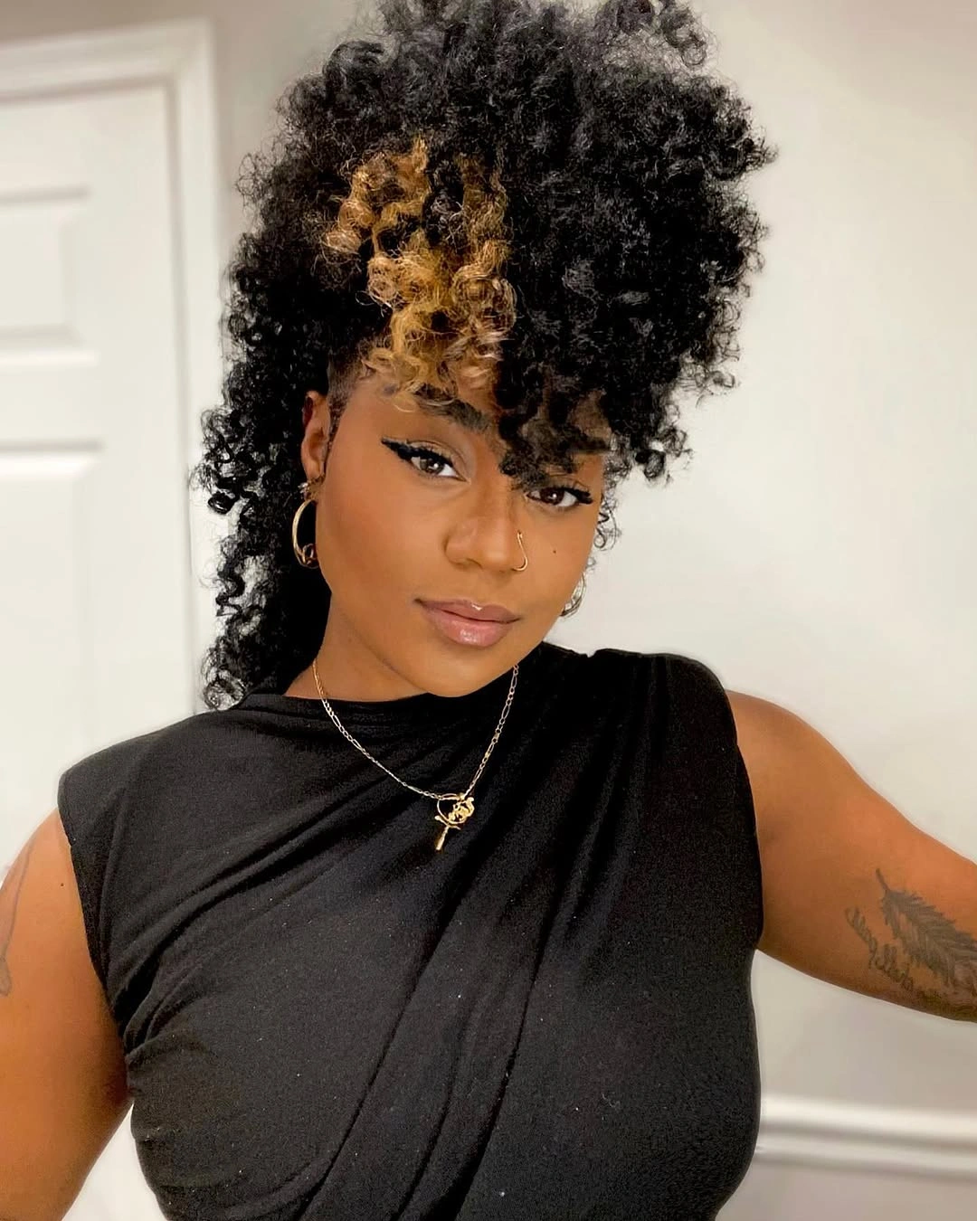 chic hairstyle ideas for black women 2027 Curly High Puff With Golden Accent
