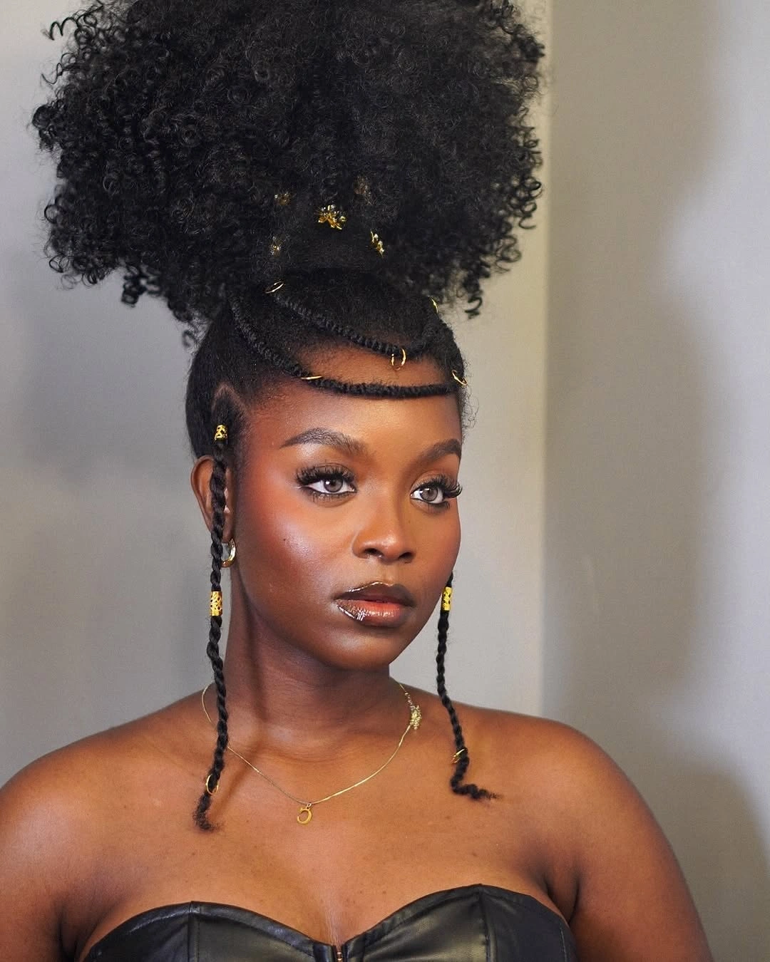 chic hairstyle ideas for black women 2027 High Braided Puff With Gold Cuffs