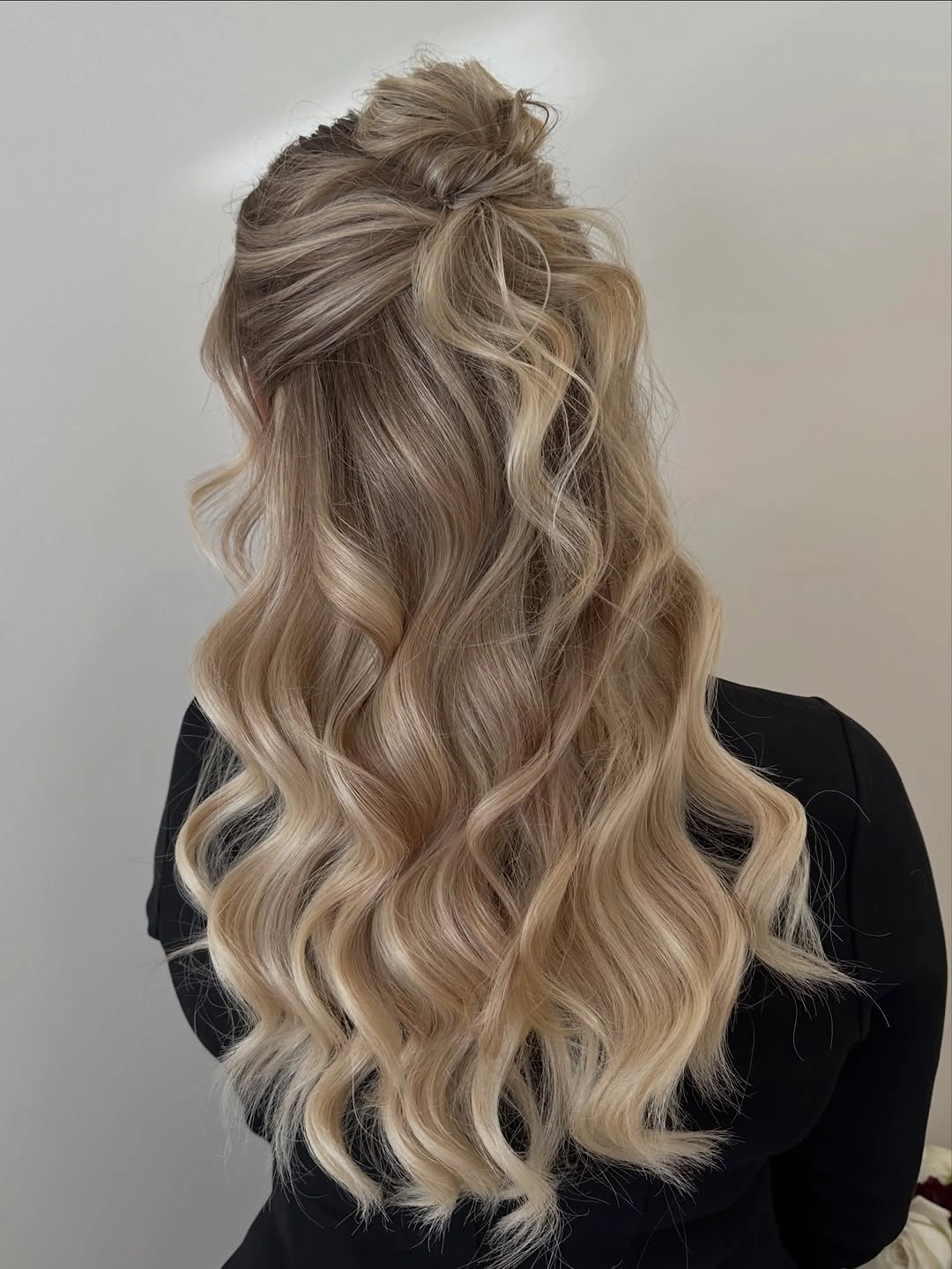 glamorous christmas hairstyles 2026 - Blonde half-up waves with a soft top knot