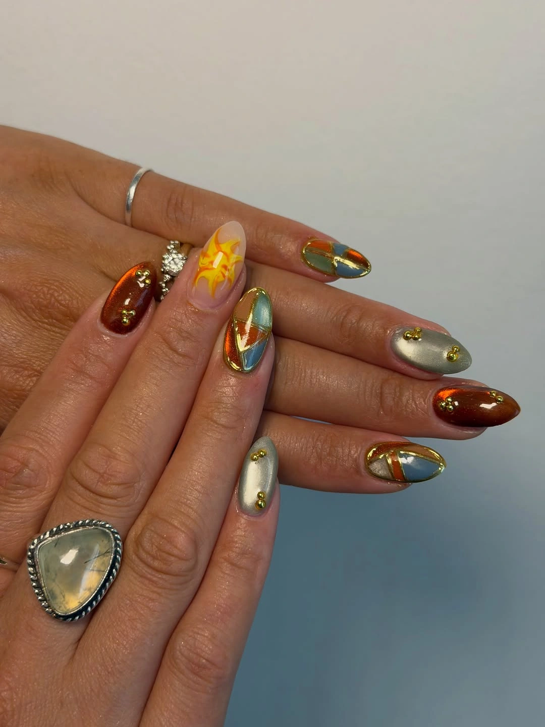trendy almond nails 2027 - Burnt Orange and Metallic Blue Almond Nails