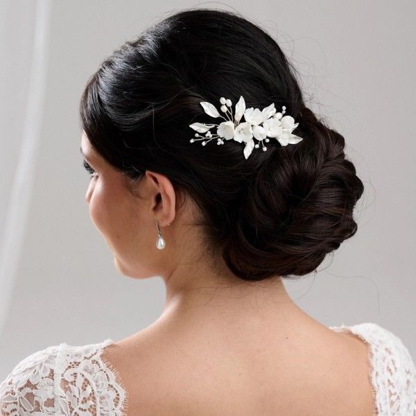 Dark Brown Low Chignon With Floral Accessory Dark Brown Low Chignon With Floral Accessory β Winter Wedding Guest Hairstyles