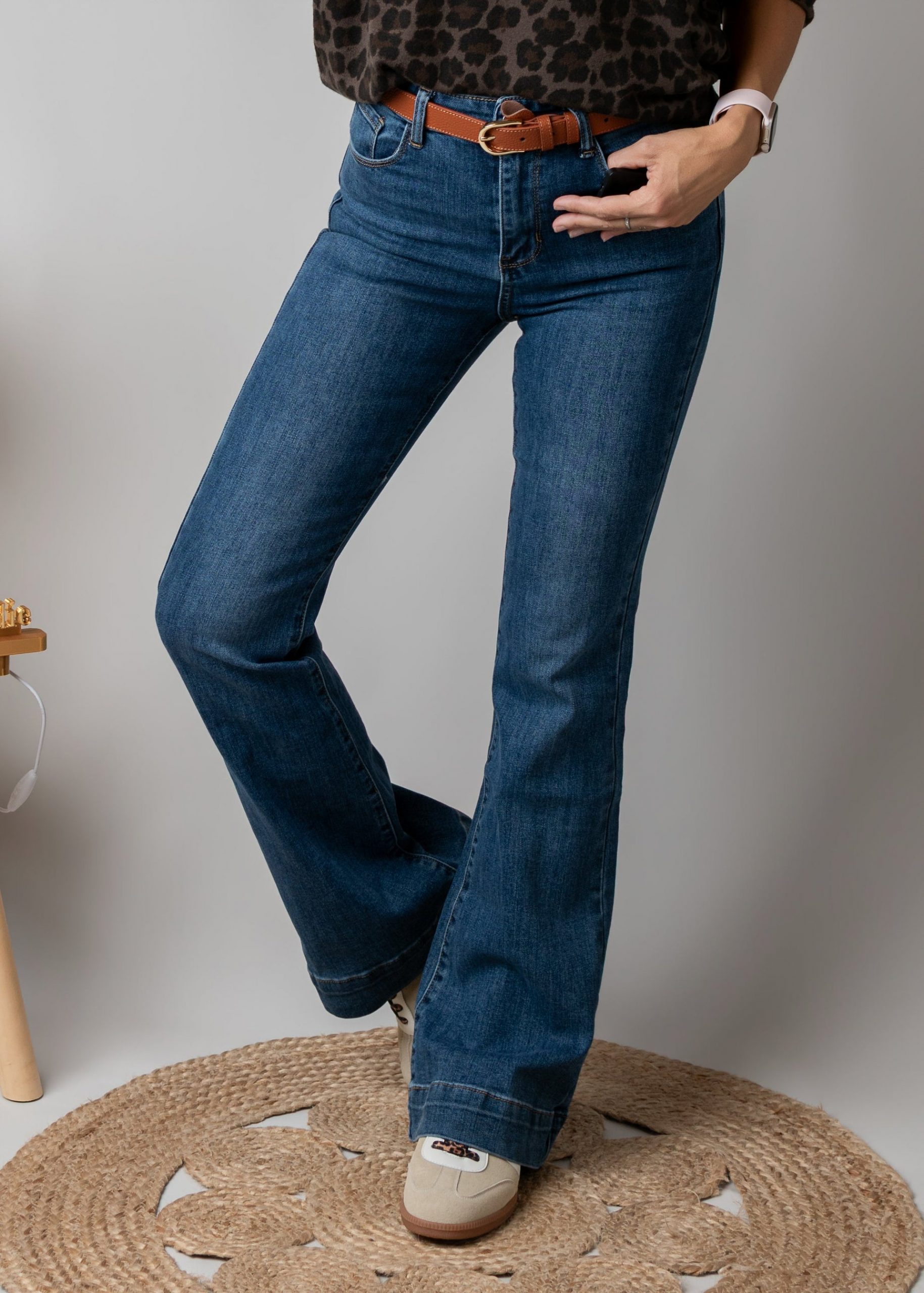 Denim Flair: Blue Flare Jeans with Beige Sneakers and Brown Belt — Flare Leggings Outfits