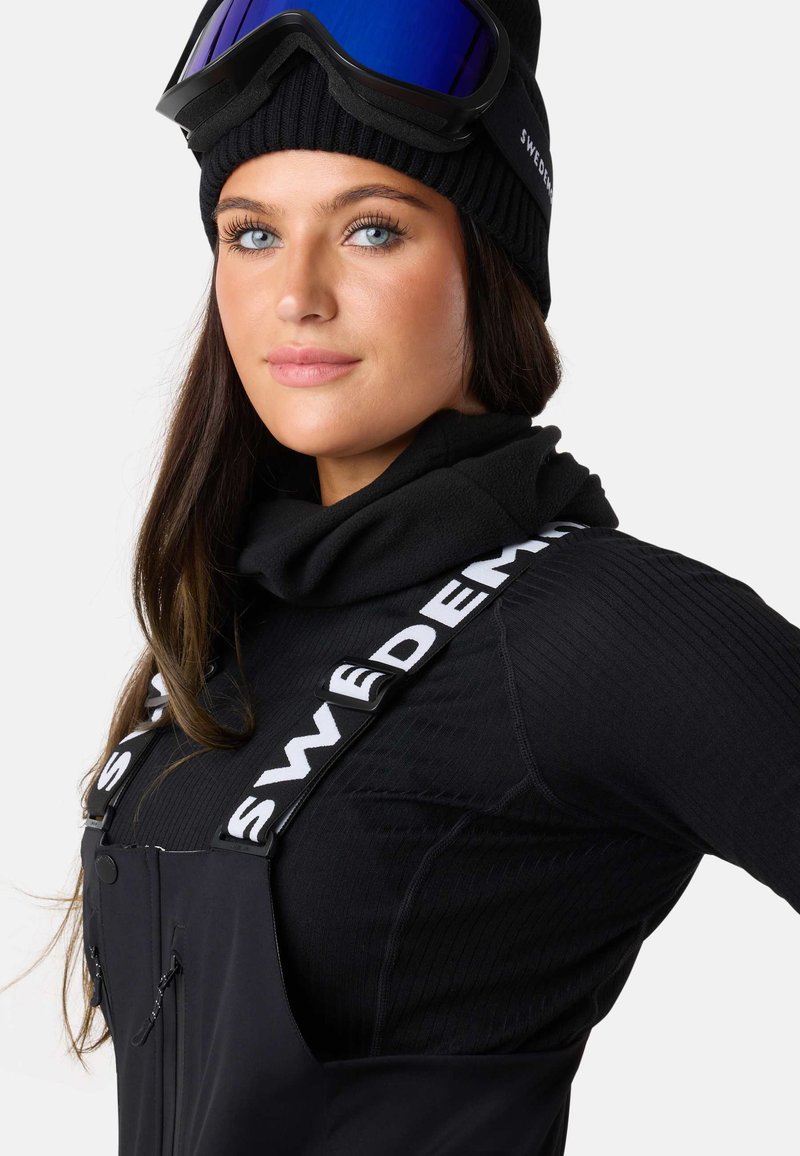 Black Ribbed Turtleneck and Bib Snow Pants for a Minimalist Snowboarding Look Black Ribbed Turtleneck and Bib Snow Pants for a Minimalist Snowboarding Look β Snowboarding Outfits