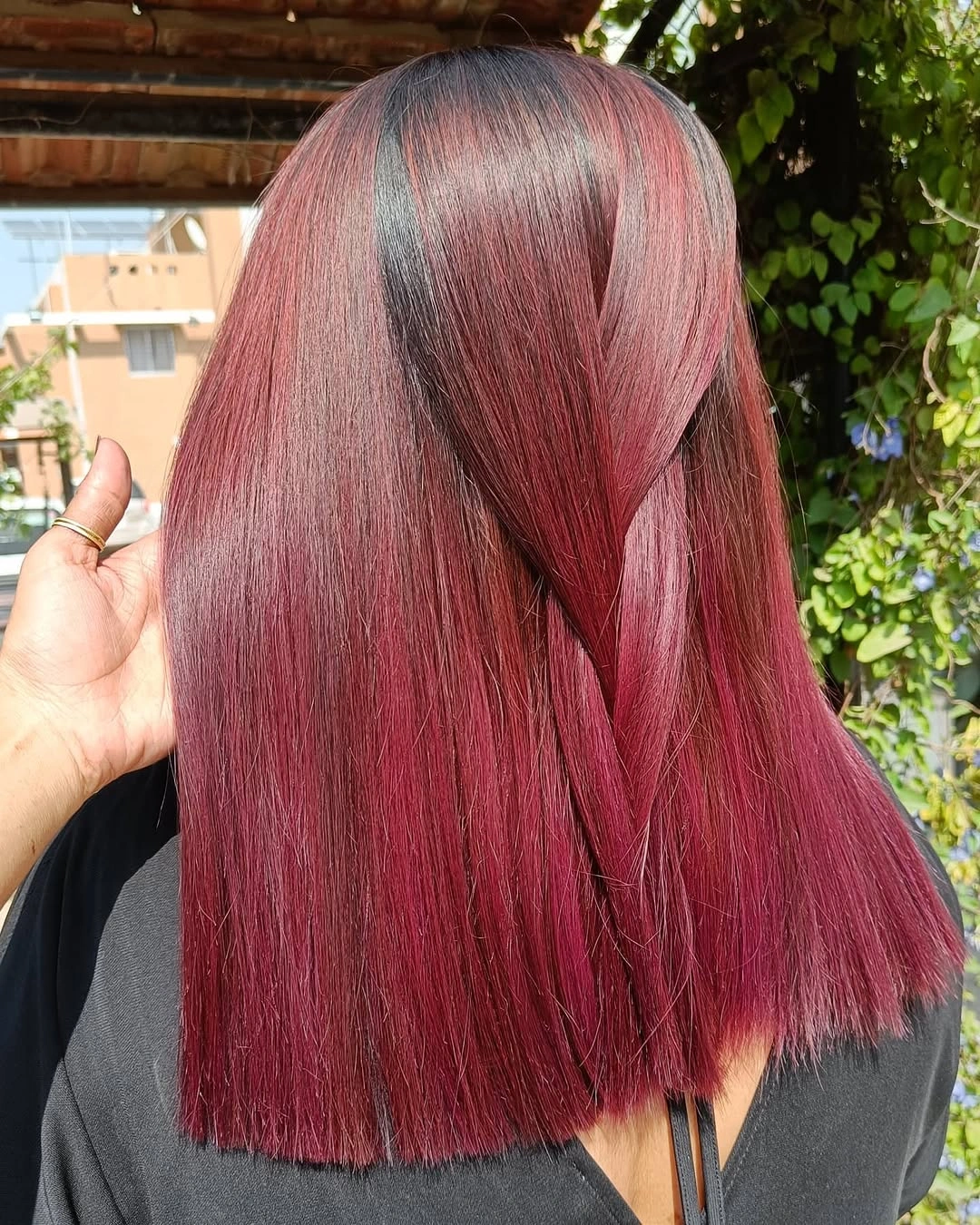 Sleek ruby magenta shoulder-length hair with a diagonal overlapping section Sleek ruby magenta shoulder-length hair with a diagonal overlapping section