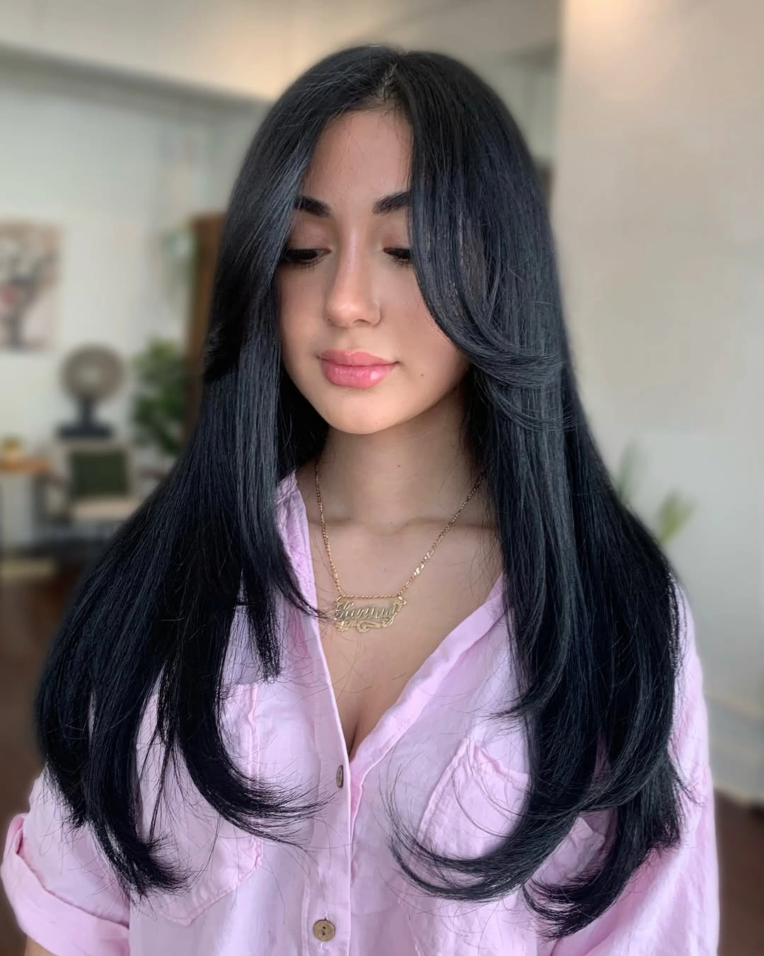 Long midnight black hair with center part and curved face-framing layers Long midnight black hair with center part and curved face-framing layers