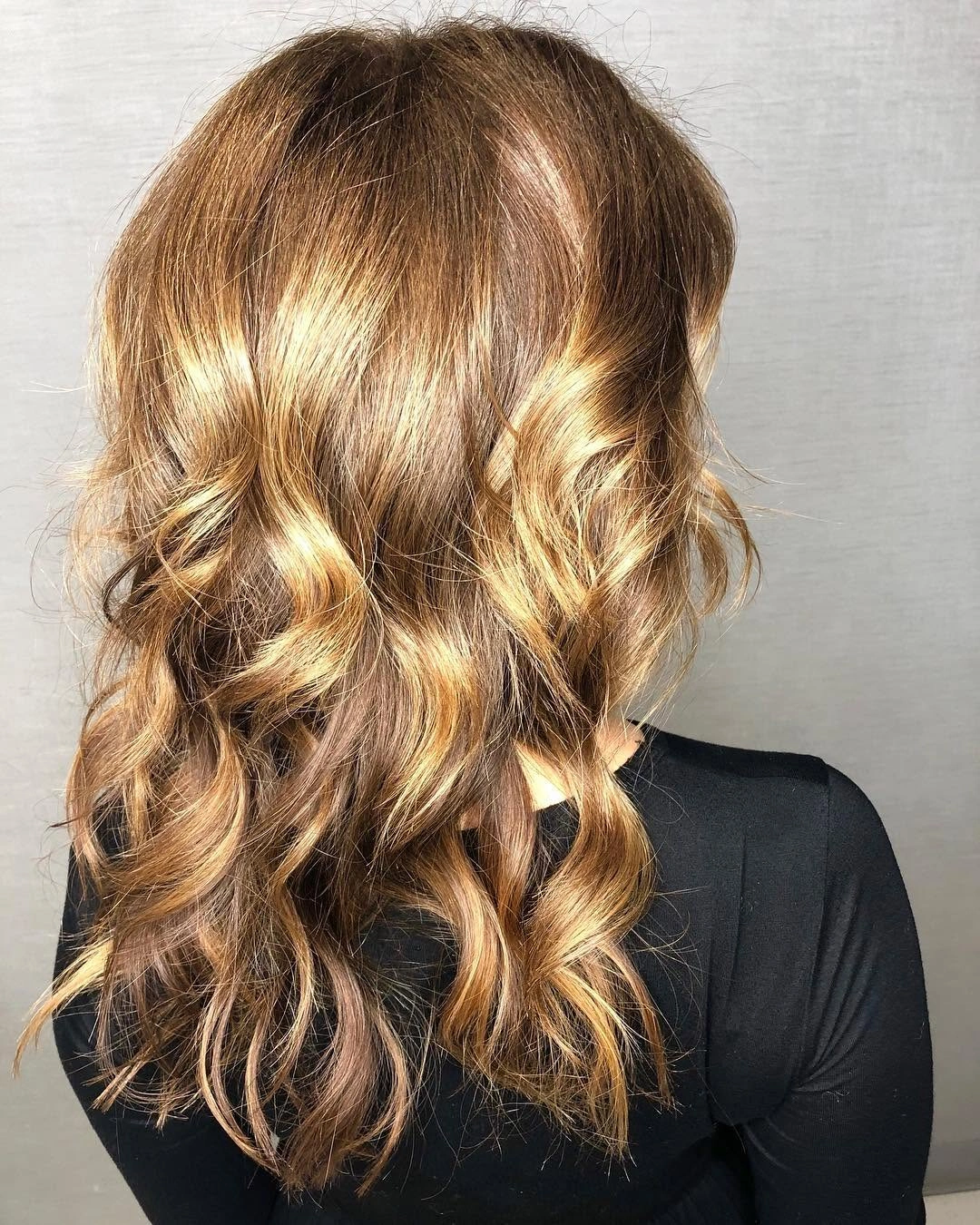 Medium-length honey brown hair with golden strands and loose curls Medium-length honey brown hair with golden strands and loose curls