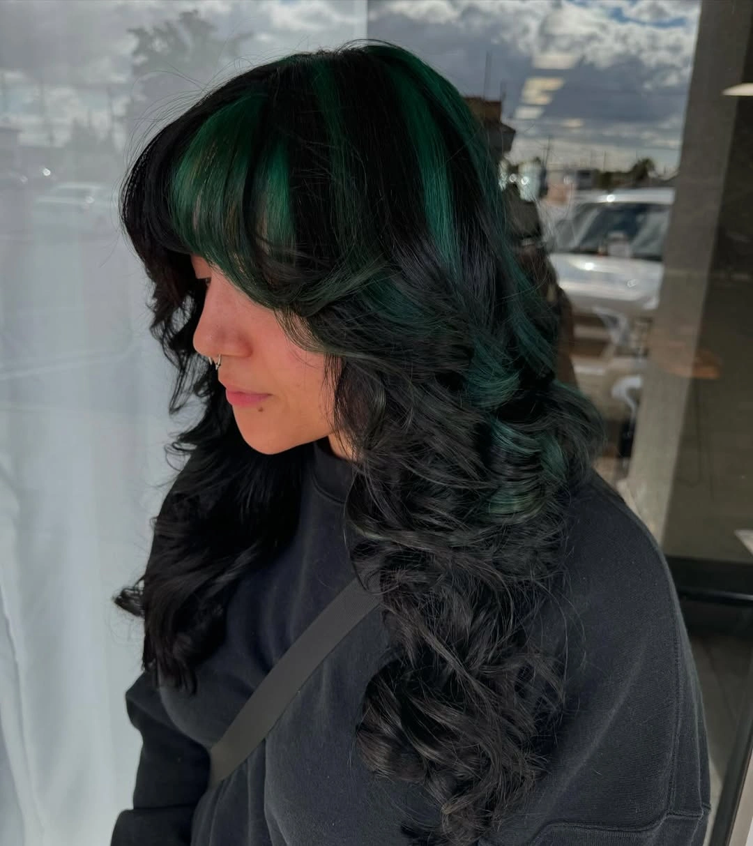 Dark layered curls with deep green reflections and rounded bangs Dark layered curls with deep green reflections and rounded bangs