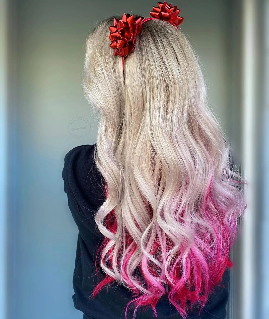 Long pale blonde curls with bright pink ends and red bow accessories Long pale blonde curls with bright pink ends and red bow accessories