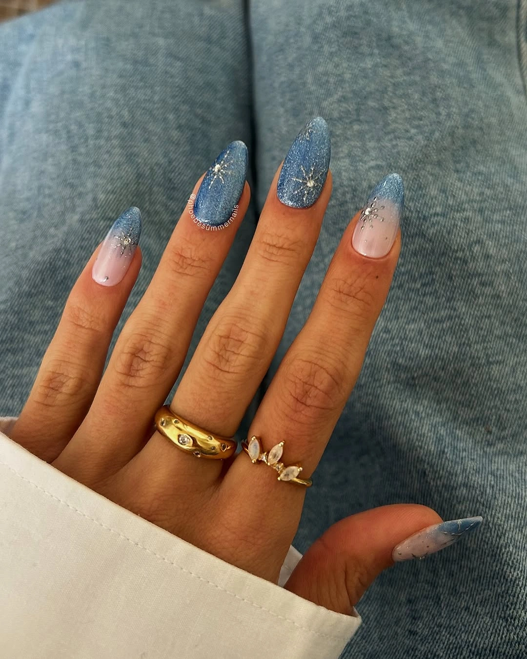 Long almond nails with steel blue glitter gradients and silver starburst accents Long almond nails with steel blue glitter gradients and silver starburst accents