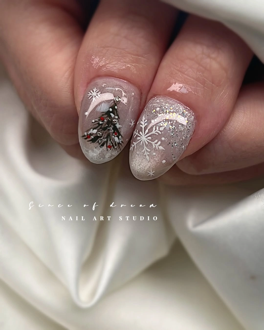 Almond nails with miniature evergreen tree white snowflakes and silver glitter Almond nails with miniature evergreen tree white snowflakes and silver glitter