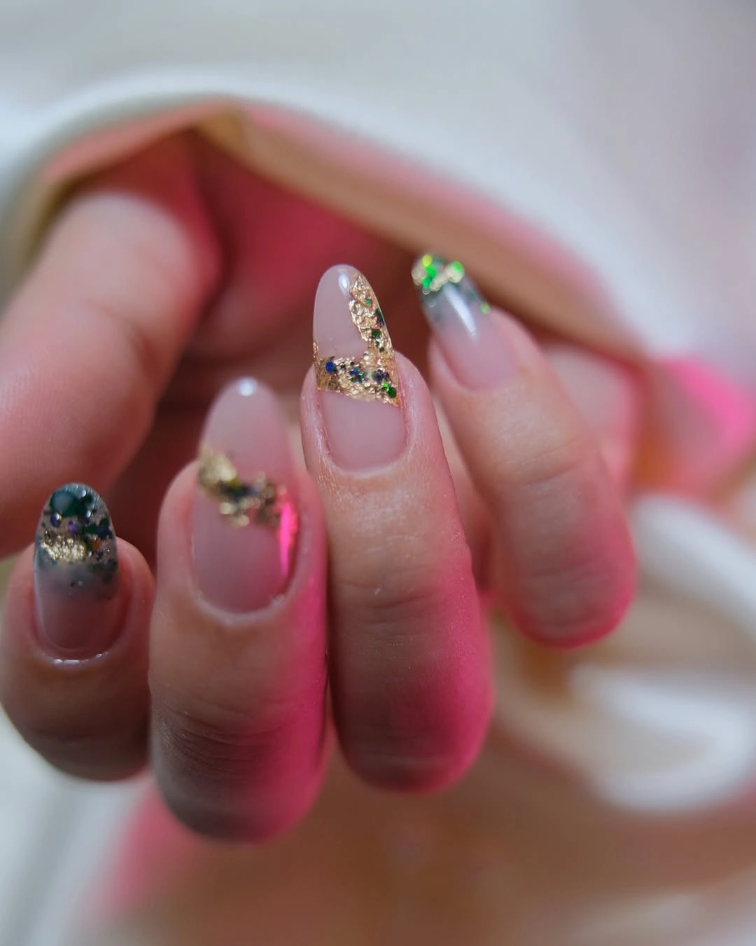 Long sheer blush almond nails with gold and green reflective accents Long sheer blush almond nails with gold and green reflective accents