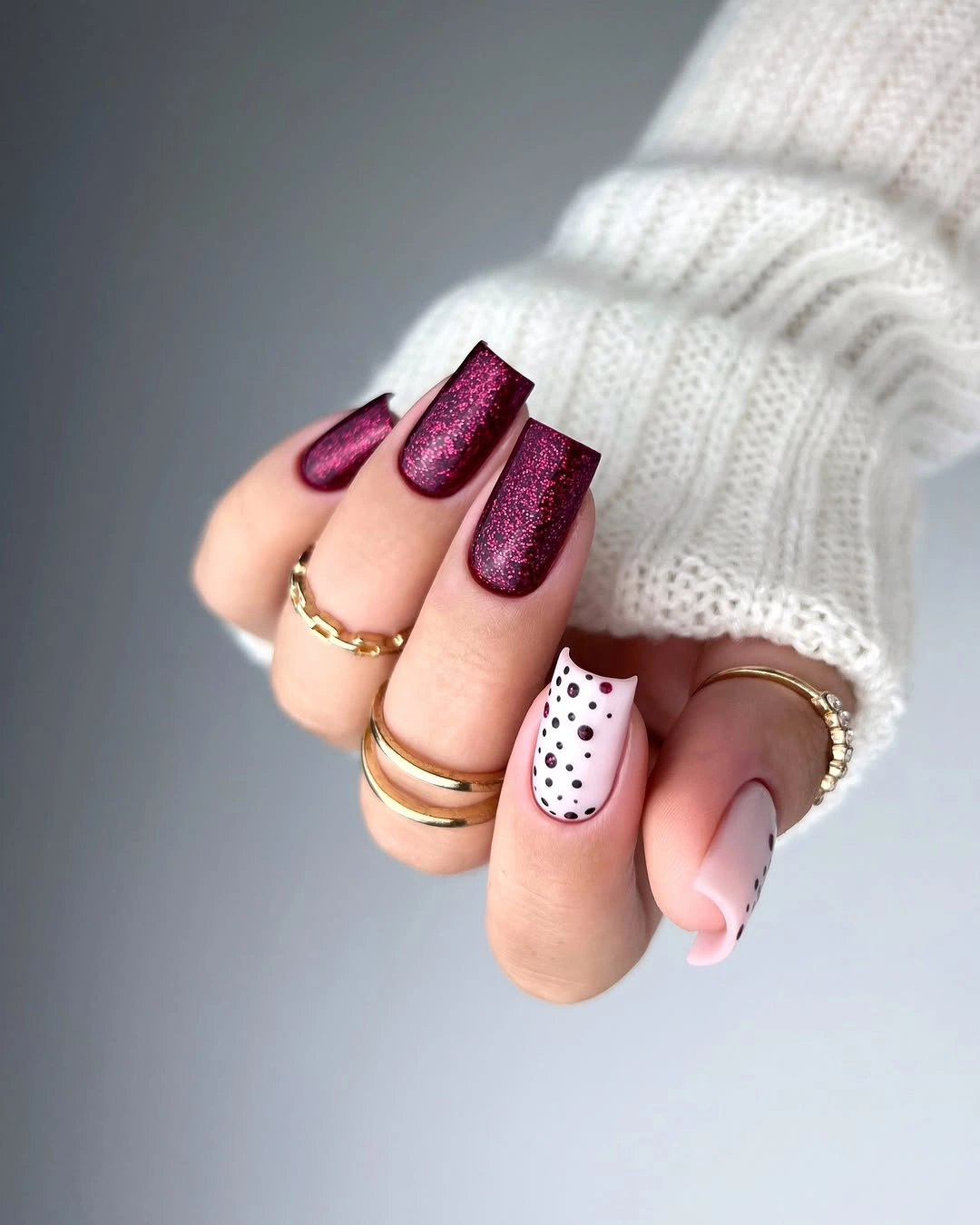Square burgundy shimmer nails with white dotted and pink graphic accents Square burgundy shimmer nails with white dotted and pink graphic accents