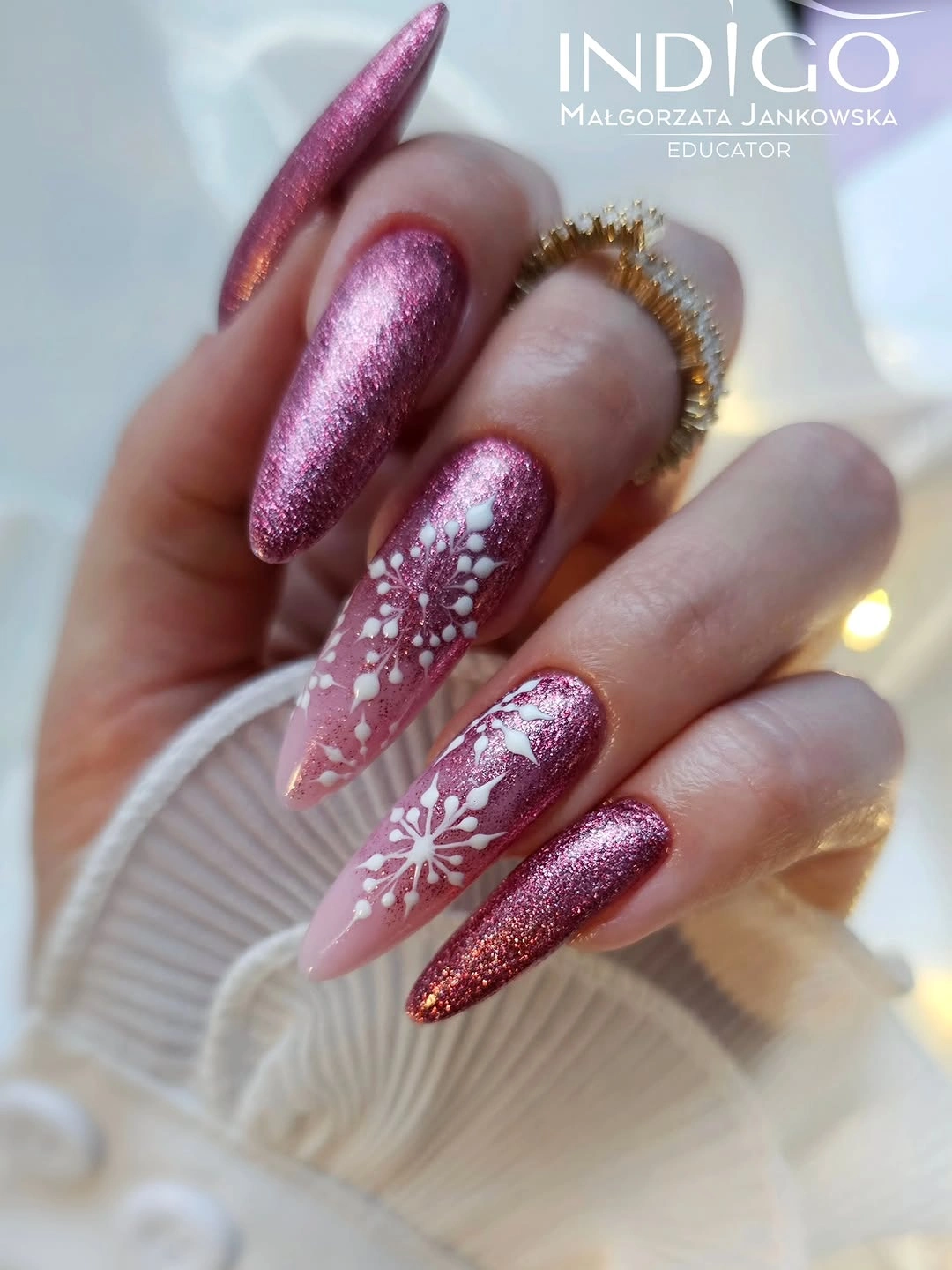 Long pointed rose shimmer nails with sheer pink snowflake accents Long pointed rose shimmer nails with sheer pink snowflake accents