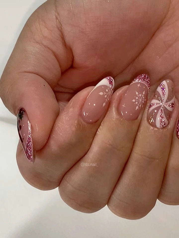 Rounded almond pink nails with glitter French tips snowflakes and candy stripes Rounded almond pink nails with glitter French tips snowflakes and candy stripes
