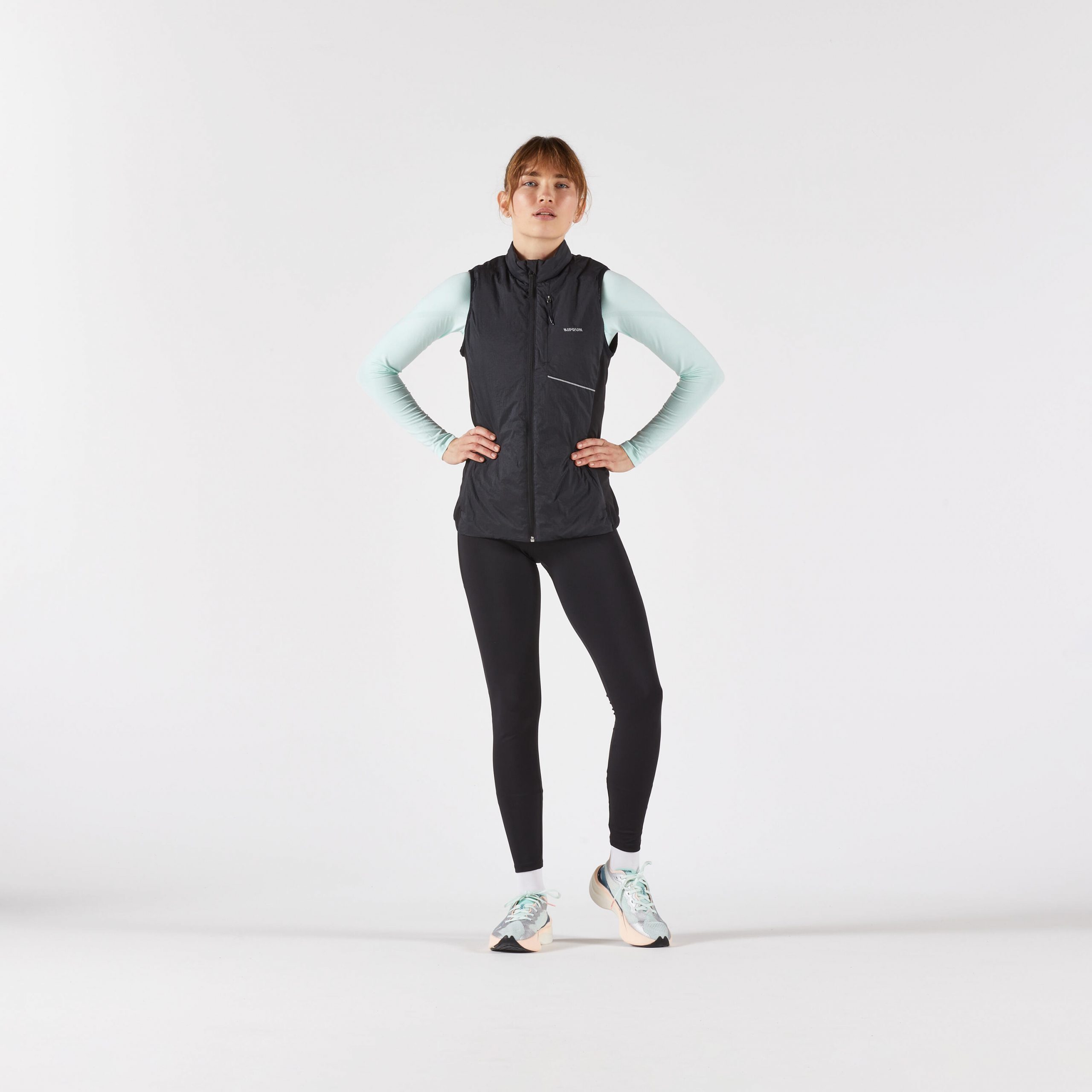Puffer Vest Over Mint Green Top for Dynamic Winter Running — Winter Workout Outfits
